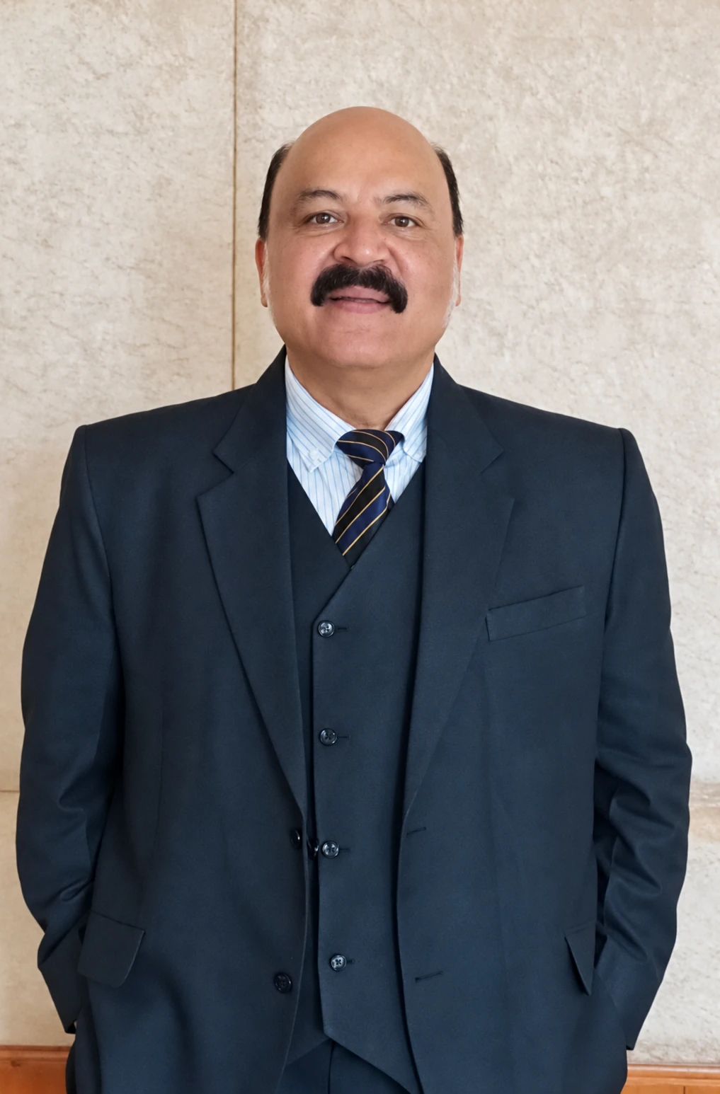 Dr Harish Kant Walia in a dark suit and striped tie